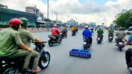 Lực lượng Công an phường Trung Mỹ Tây cùng Đoàn thanh niên phường chạy xe hút đinh trên Quốc lộ 1 đoạn qua địa bàn Quận 12.