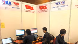 Các phóng viên tác nghiệp tại Trung tâm báo chí trong ngày đầu làm việc của Đại hội Đảng XIII