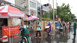 Người dân đội mưa đi tiếp tế tại phường Chương Dương do bị cách ly thêm 14 ngày