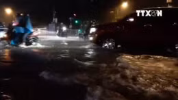  Người dân TP Hồ Chí Minh bì bõm đi lại trong mưa bão