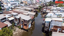 Những căn nhà lụp xụp, cũ nát được ốp bằng tôn tạm bợ mọc san sát nhau ven rạch Xuyên Tâm.