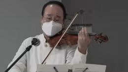 Nghệ sĩ đeo khẩu trang, chơi violin an ủi bệnh nhân COVID-19